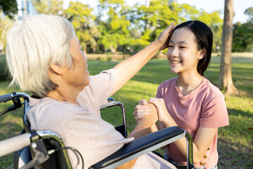 Obraz premium Happy asian senior grandmother is stroking her loving granddaughter head,support, care,old elderly and smiling child girl hand in hand with love,nostalgia while visiting her on weekend at nursing home