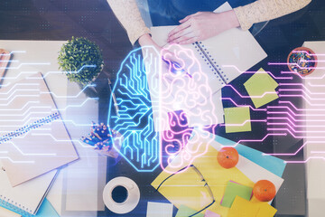 Double exposure of writing hand on background with brain hologram. Concept of learning.