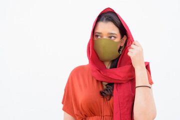 Face of young Indian woman with headscarf and mask thinking against white background