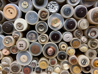 Close up of isolated stacked round boxes in an row with countless trouser buttons