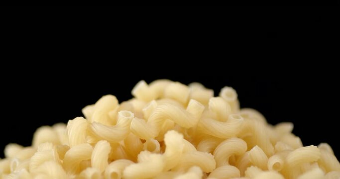 Handful of dry pasta cavatappi on table slowly rotates.