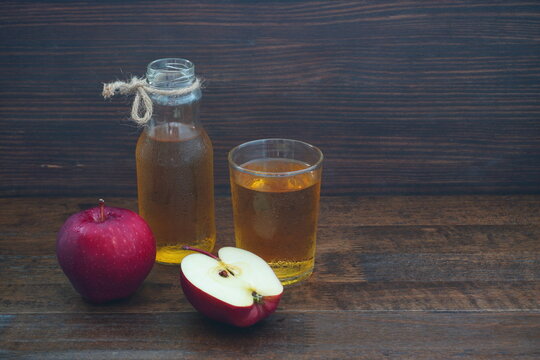 Apple juice in a glass And red ripe apples On an old wooden bar