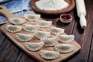 raw dumpling with cherries on the wooden board