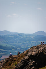 People looking out over rolling hills of north wales shot from the top of The Wrekin in Shropshire