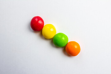 Four multi-colored sweets on a white background close-up