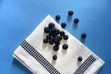 Blueberry on blue background. Blueberries on a beige towel