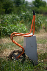 Muddy Wheel barrow upright on filed with blurred background