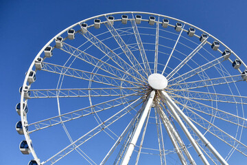 The Great Smoky Mountain wheel at The Island in Pigeon Forge, Tennessee, USA.  The giant wheel is set against a plain bright blue cloudless sky background