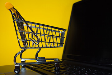 E-Commerce. Online shopping, shopping cart on laptop keyboard.