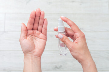 Hand disinfection. hand takes alcohol disinfectant spray on her hands.