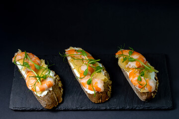 fresh bruschetta with shrimp, cheese, ham and microgreens