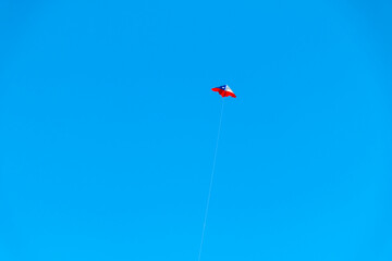 Chilean flag kite design flying against a blue sky