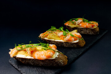 fresh bruschetta with shrimp, cheese, ham and microgreens