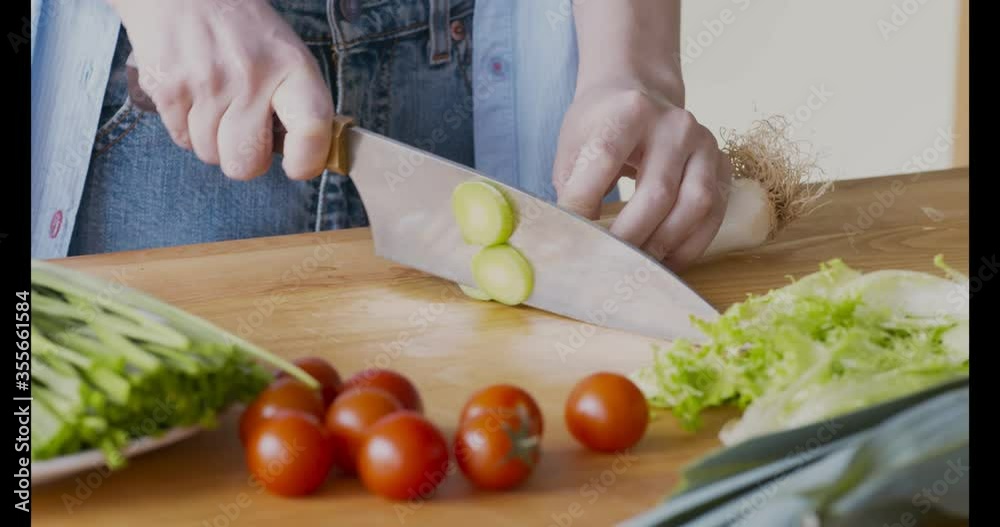 Sticker woman slicing fresh green leek for healthy vegetable salad