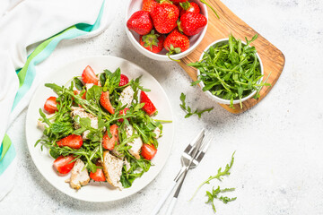 Green salad with chicken, strawberry and arugula.