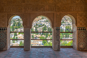 Albaicin district viewed through decorated windows of Torre de las damas at Alhambra palace in...