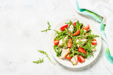 Green salad with chicken, strawberry and arugula.