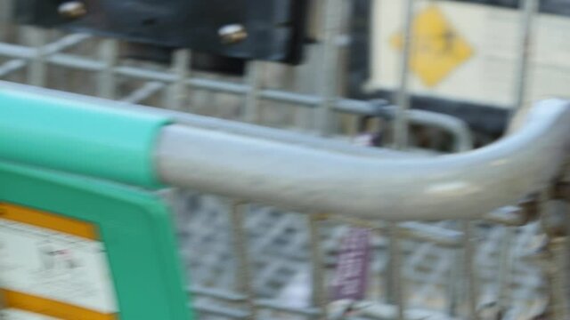 Close-up Of Hands Wiping Down And Sanitizing A Grocery Store Shopping Cart During The COVID-19 Pandemic