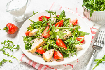 Green salad with chicken, strawberry and arugula.