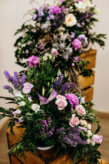 Beautiful wedding decoration of mixed flowers on wooden boxes. Bunch of fresh flowers in different colors