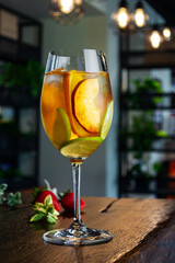 white wine cocktail with slices of peach lime and orange