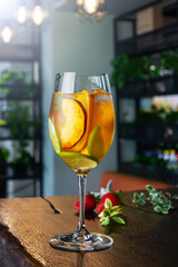 white wine cocktail with slices of peach lime and orange