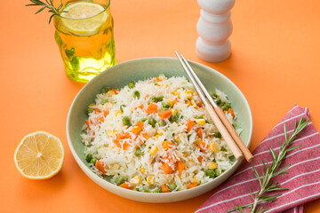 A plate of white rice with vegetables on a stylish trending orange background, Asian food
