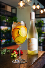 white wine cocktail with slices of peach lime and orange