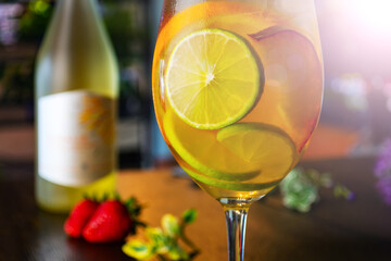 white wine cocktail with slices of peach lime and orange