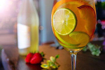 white wine cocktail with slices of peach lime and orange