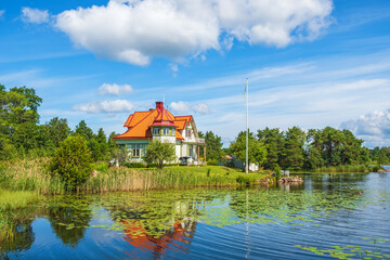 Fototapeta na wymiar Idyllic house on a hill at a beautiful lake