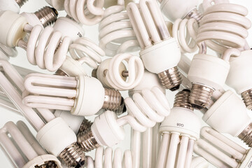 Spiral Energy saving fluorescent electric light bulbs. Old burnt lamps - obrazy, fototapety, plakaty