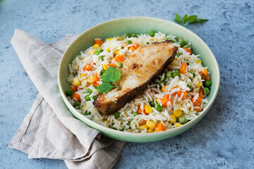 Close up Rice with vegetables and fish steak in a plate, selective focus