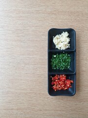 Chopped garlic chillies and spring onion on a table