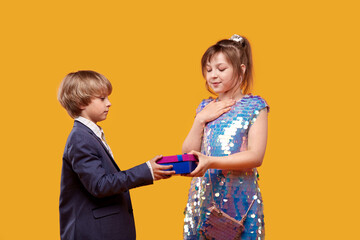 Cute beautiful girl accepts a gift from a boy. Holiday clothes.