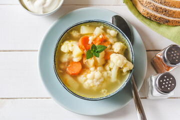 Cauliflower soup with vegetables in a bowl.