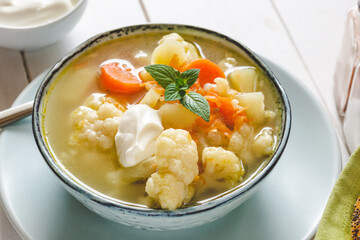 Cauliflower soup with vegetables in a bowl.