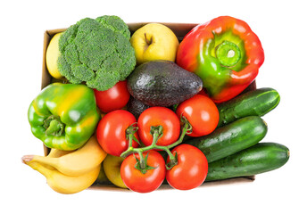Different vegetables, fruits in cardboard box on white, top view. Healthy vegetarian food. Food donation, online shopping or contactless delivery service concept. Avocado, pepper, tomato and broccoli