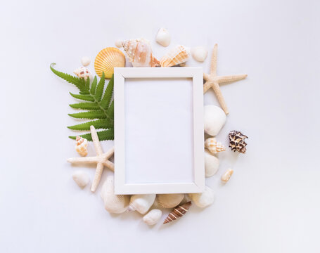 Top view, beach, shell and white picture frame.
