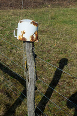 Alter verosteter Topf hängt auf einem Zaunpfahl