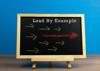 LEAD BY EXAMPLE on a chalkboard with arrow drawing, conceptual