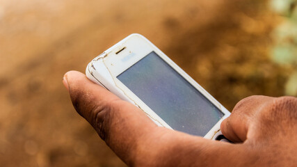 A hand of a man tayping with an old mobile