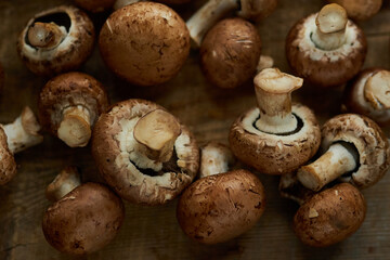 Champignon mushrooms on a wooden board. Fresh healthy brown mushrooms.