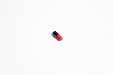 a red blue capsule with shadow below isolated on a white background