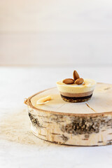 Cashew cake with chocolate, almonds and lemon on a wooden board. No sugar, gluten, lactose.