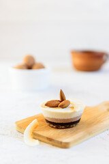 Cashew cake with chocolate and almonds on a wooden board. No sugar, gluten, lactose.