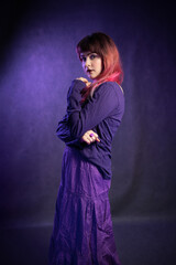Beautiful girl in studio portrait in violet-blue image. Portrait of young woman in creative image