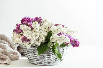 Spring composition with lilac flowers in a wicker basket.