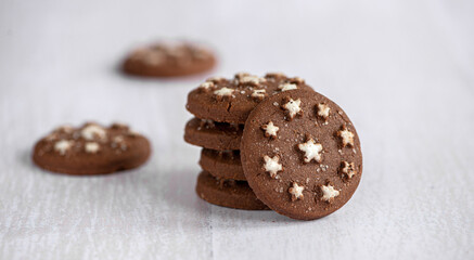 Homemade crispy cocoa and hazelnut brown round cookies stacked on the table