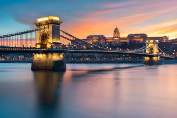 Fototapeta premium Buda castle with Szechenyi Chain Bridge foreground reflect in Danube river during sunset